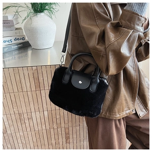 Detail of black faux fur handbag with leather handles and silver metal buckle closure