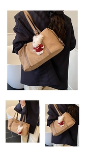 Detail of a brown matte suede tote bag featuring a cute white rabbit charm accessory