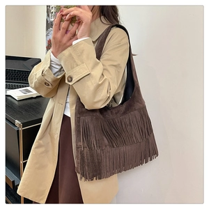 Detail view of large dark brown hobo bag featuring decorative long suede fringes
