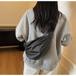 Vue arrière du sac bandoulière noir minimaliste avec sangle large réglable