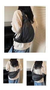 Detail of black nylon crossbody bag with adjustable wide strap and water-resistant fabric