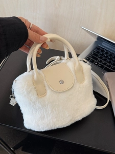 White faux fur handbag with leather handle and adjustable strap for shoulder or crossbody use