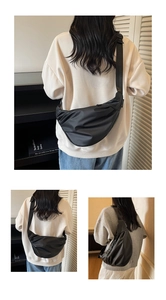 Detail of black crescent crossbody bag with adjustable wide strap for daily commute