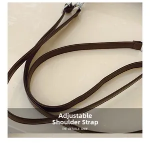 Close-up of adjustable dark brown faux leather shoulder strap with silver swivel hook