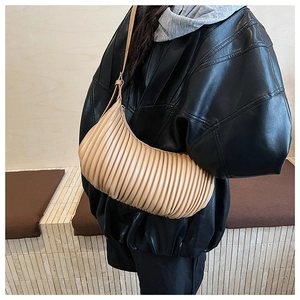 Detail of pleated vertical stripes on a cream beige underarm bag with a slim strap