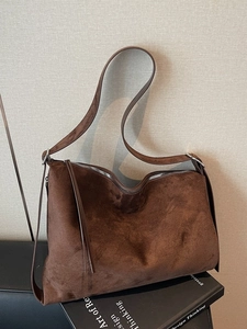 Vintage bruine suède hobo tas met zilveren hardware in een stijlvolle setting