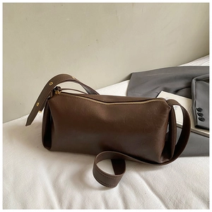 Détail d'un sac baguette vintage marron foncé avec texture cuir et zip doré