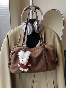 Brown faux suede tote bag with plush dog charm and long handles for shoulder wear