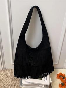 Large black suede hobo tote bag with long fringe tassels and wide shoulder strap