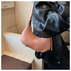 Detail of pink pleated crescent bag showing textured accordion folds and silver zipper
