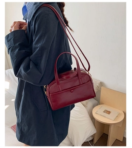 Modèle portant un sac bowling bordeaux avec bandoulière réglable et poche à bouton