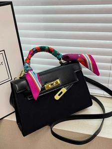 Classic black leather satchel bag with elegant silk scarf wrap and gold hardware