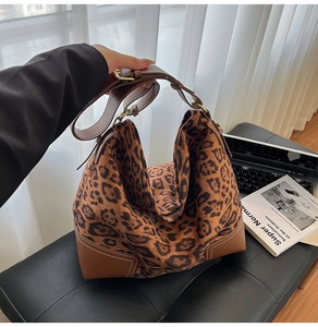 Detail of leopard print suede tote with brown leather stitching and white seam details