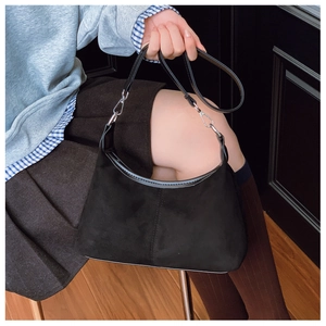 Detail of vintage black suede hobo bag featuring smooth leather trim and silver metal buckles