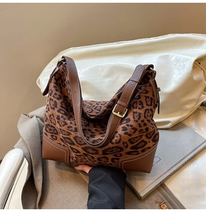 Detail of leopard print suede tote bag with brown leather corners and contrast stitching