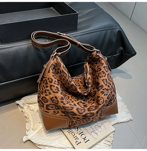 Detail of leopard print suede tote with brown leather trim and reinforced base