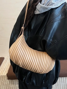Chic beige pleated croissant shoulder bag with adjustable strap worn by a model
