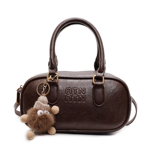 Sac cylindrique en cuir marron foncé avec gaufrage ATN et charmant monstre en peluche