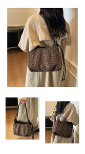 Detail view of leopard print tote bag with black drawstring straps and canvas texture