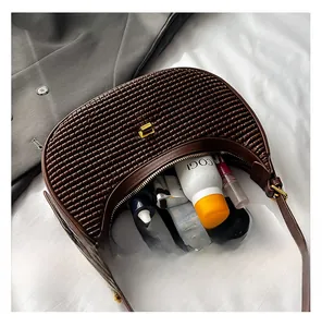 Deep brown woven crescent shoulder bag showing internal capacity for daily essentials