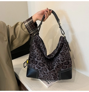 Detail of hobo bag featuring leopard pattern, black leather corners and contrast stitching