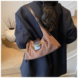 Détail du sac cabas en patchwork de suède avec boucle en croissant porté par un mannequin