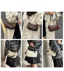 Vue détaillée des sacs bandoulière en cuir avec chaîne dorée et breloques cerise