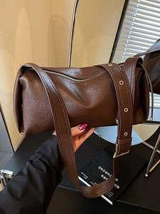 Sac baguette en cuir marron foncé avec large bandoulière à œillets et fermeture zippée