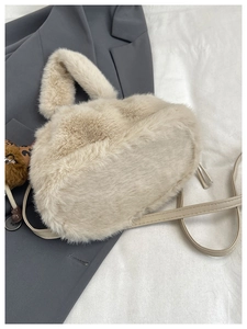 Detail of beige plush bucket bag with leopard charm and detachable crossbody strap