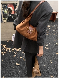 Détail du sac cabas en suède avec ferrures dorées et bandoulière en cuir lisse