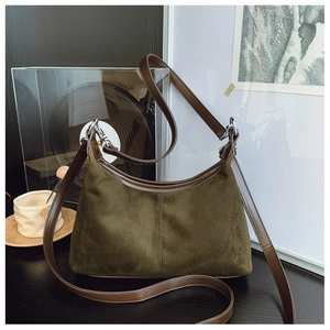 Close-up of olive green suede and brown leather texture on a vintage hobo shoulder bag