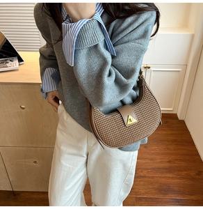 Close-up of brown woven texture hobo bag with vintage gold triangular twist lock