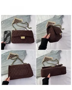 Detail view of brown quilted crossbody bag with gold chain strap and turn-lock closure