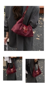 Détail du sac d'épaule bordeaux en daim avec boucle dorée porté par un modèle