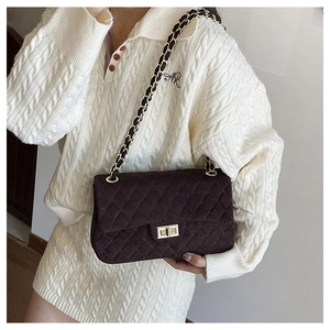 Detail of vintage quilted velvet flap bag with gold metal twist lock and chain strap