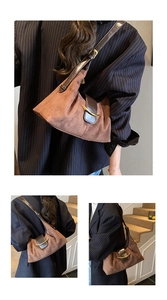 Gros plan d'un sac sous le bras en daim marron avec boucle crochet dorée et cuir