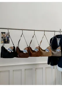 Detail view of large suede hobo bags in five colors with metal chain straps and bear charms