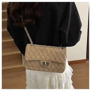 Detail of khaki quilted chain bag with a gold metal twist lock on a minimalist texture