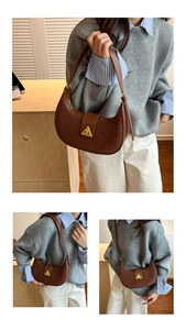 Detail view of brown woven texture shoulder bag featuring gold triangle buckle hardware