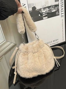 Beige plush drawstring bucket bag with soft faux fur texture and versatile shoulder strap