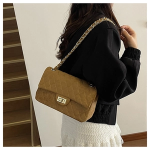 Brown quilted chain bag with gold twist lock and suede texture on model back