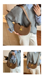 Detail of a brown crescent shoulder bag with woven texture and a gold metal clasp