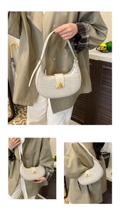 Creamy white half-moon shoulder bag with woven texture and gold triangle logo plate