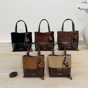 Chic bucket bag in split suede and leather with acorn pendant and shoulder strap
