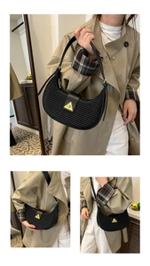 Detail of woven hobo bag with gold triangle clasp showing shoulder and crossbody wear