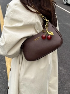 Sac bandoulière chic en cuir marron foncé avec chaîne dorée et breloque cerise