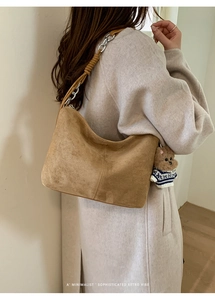 Detail of retro suede tote bag featuring woven chain strap and cute teddy bear charm