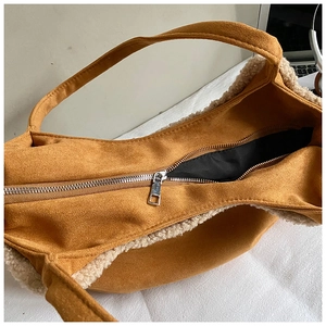 Detail view of suede tote bag with faux shearling trim and silver metal zipper