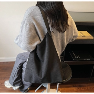 Lifestyle shot showing the back of a large matte black suede tote bag for daily use