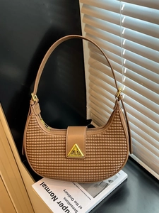 Brown hobo shoulder bag with woven texture and gold triangle hardware on black surface